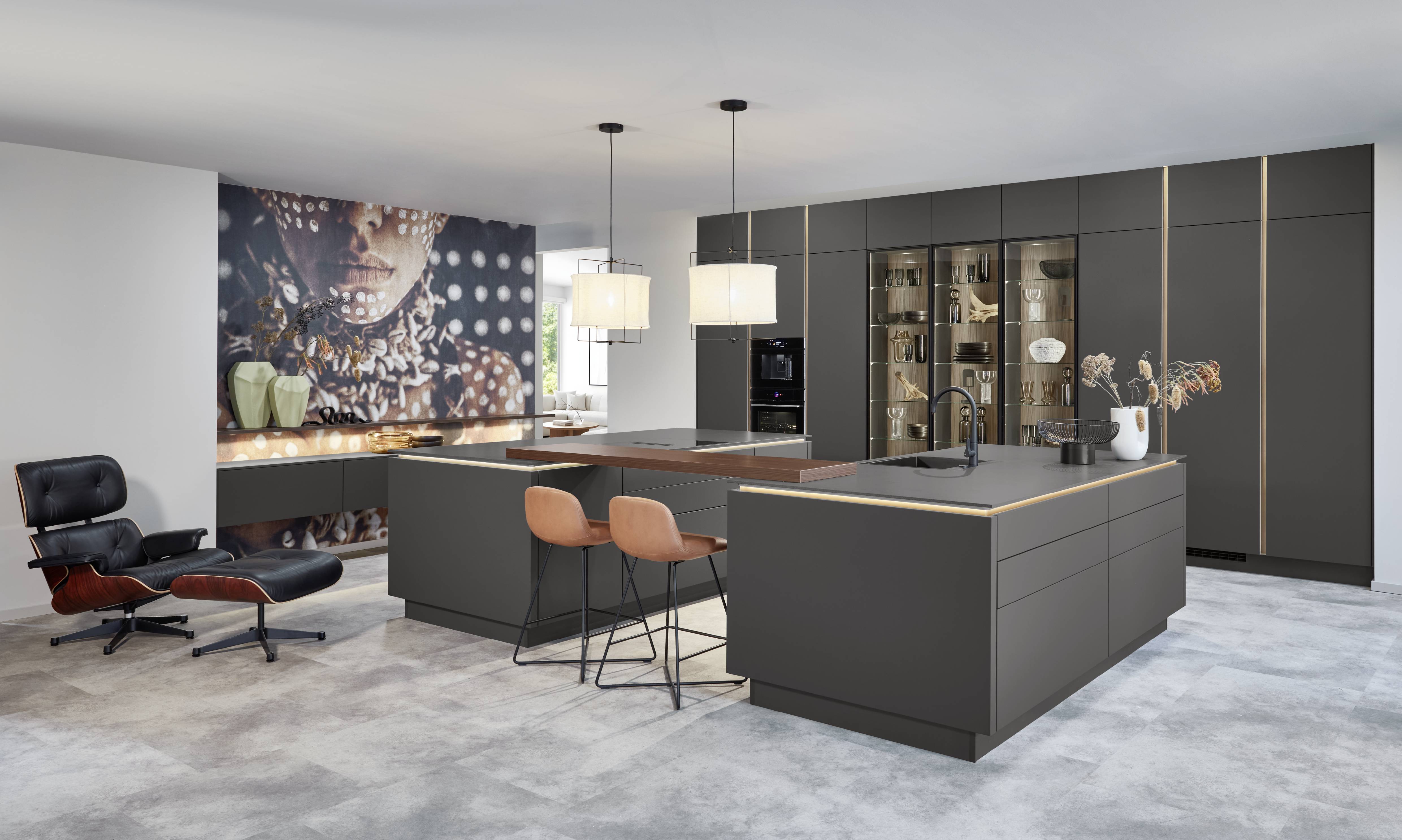 Charcoal modern kitchen with two large islands, pendant lights, glass display cabinet, and subtle metallic trim accents.