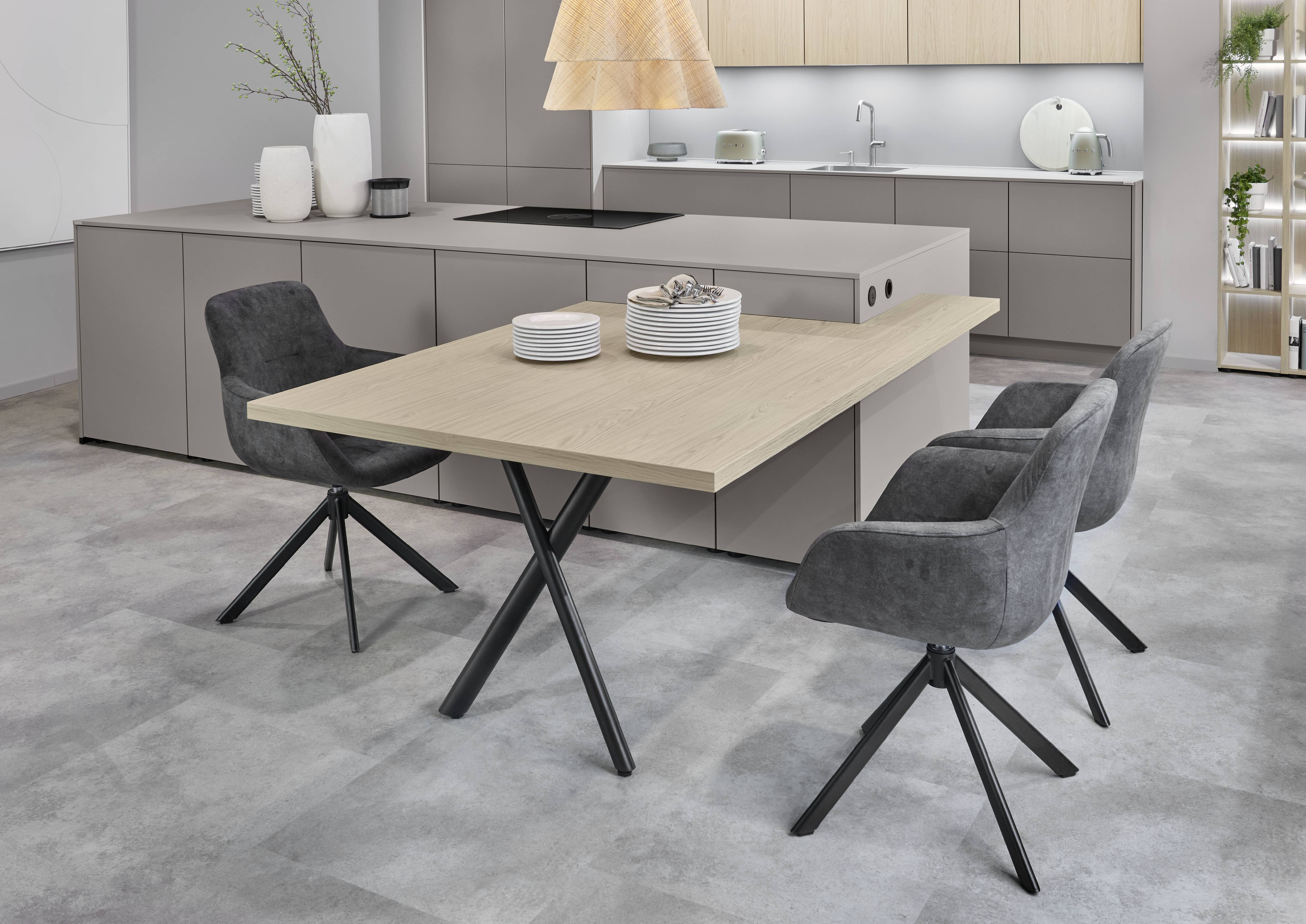 Modern Kitchen Island with Integrated Dining Table Extension Modern kitchen with a minimalist taupe island, integrated cooktop, and a natural wood table extension paired with upholstered dining chairs.