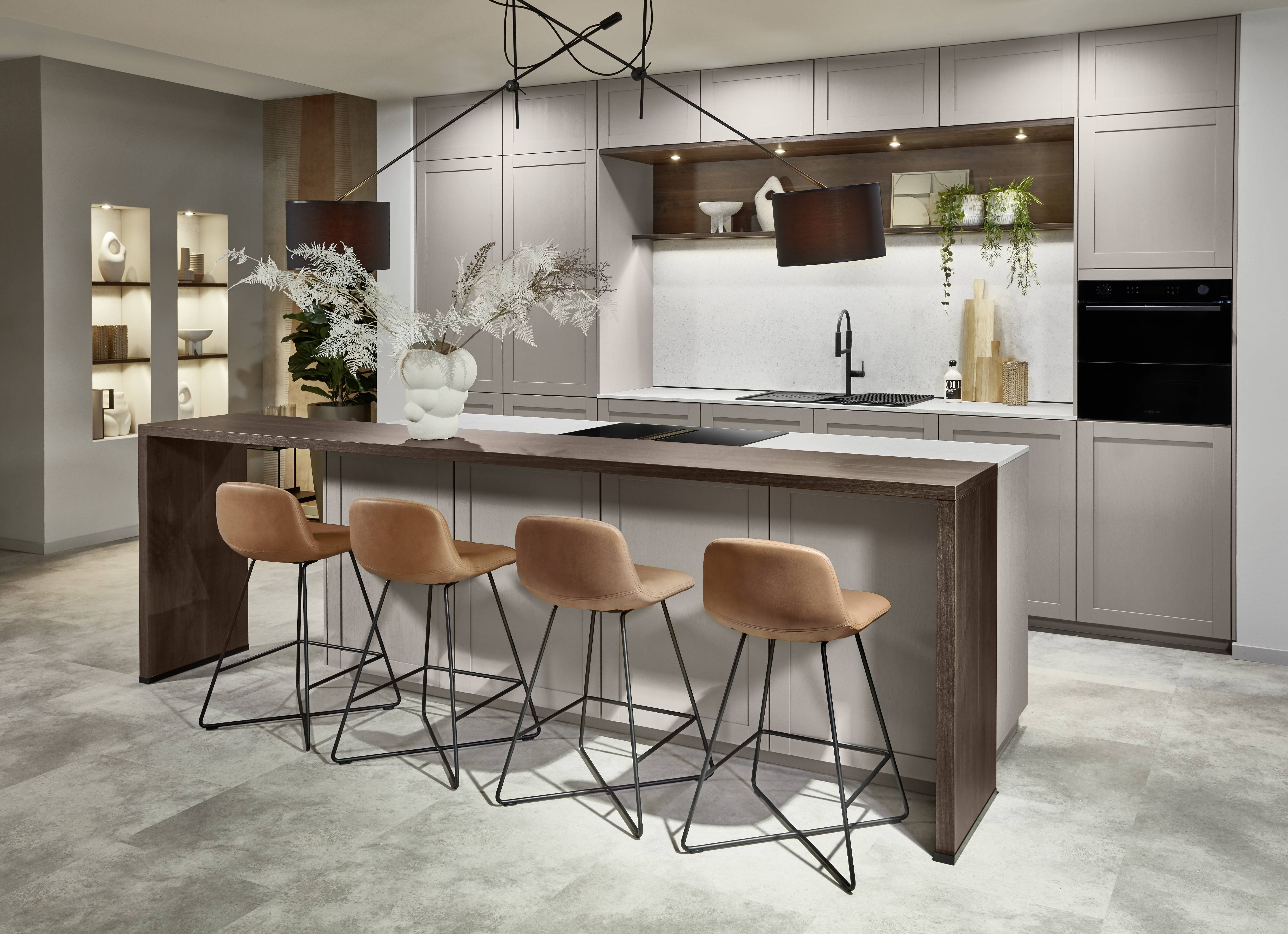 Industrial-inspired kitchen with statement pendant lighting, tailored cabinetry, and a generous island with warm wood-look accents.