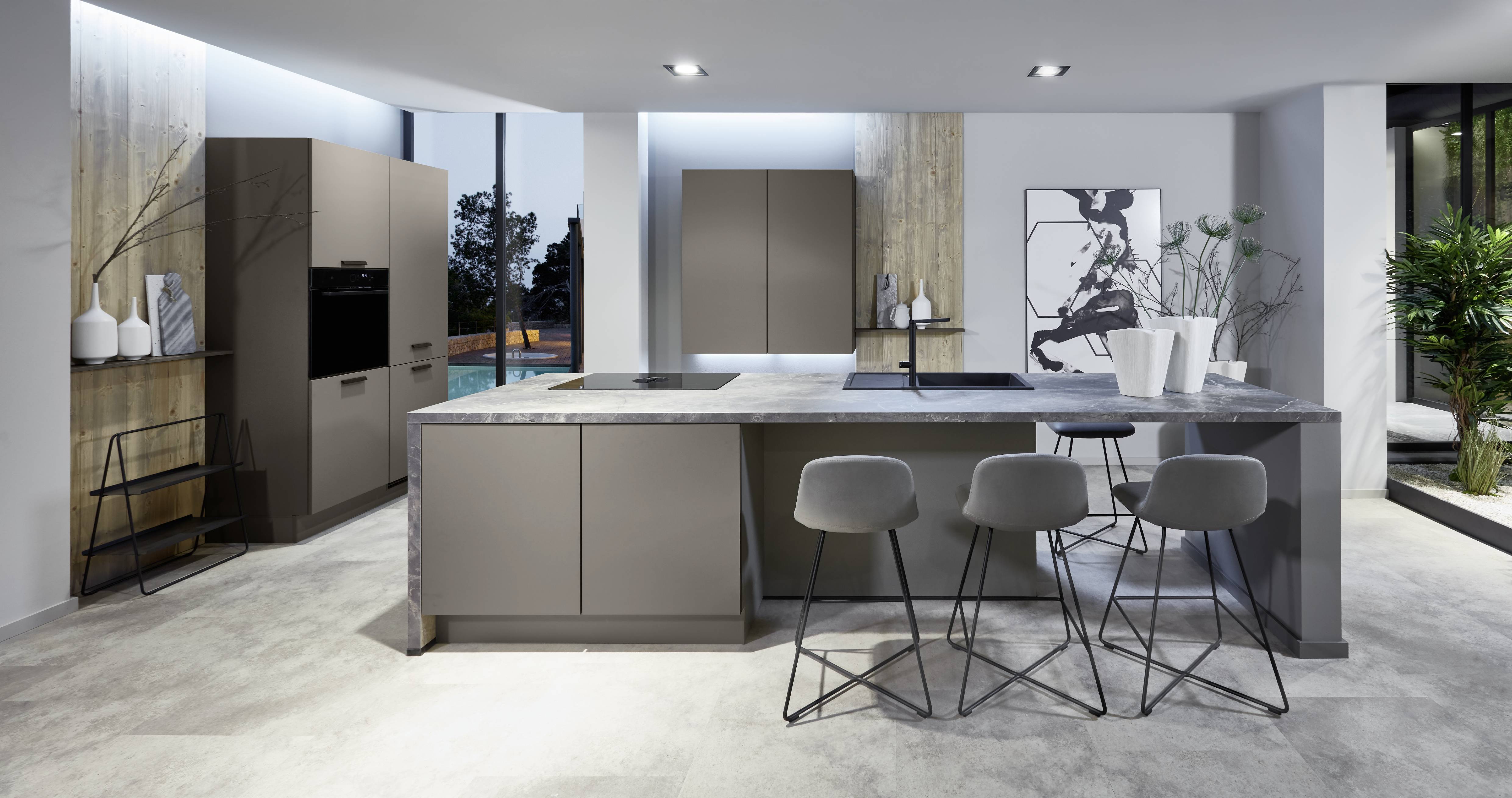 Contemporary grey kitchen with large island Contemporary kitchen with a large grey island, matching cabinetry, and bar seating in an open-plan space