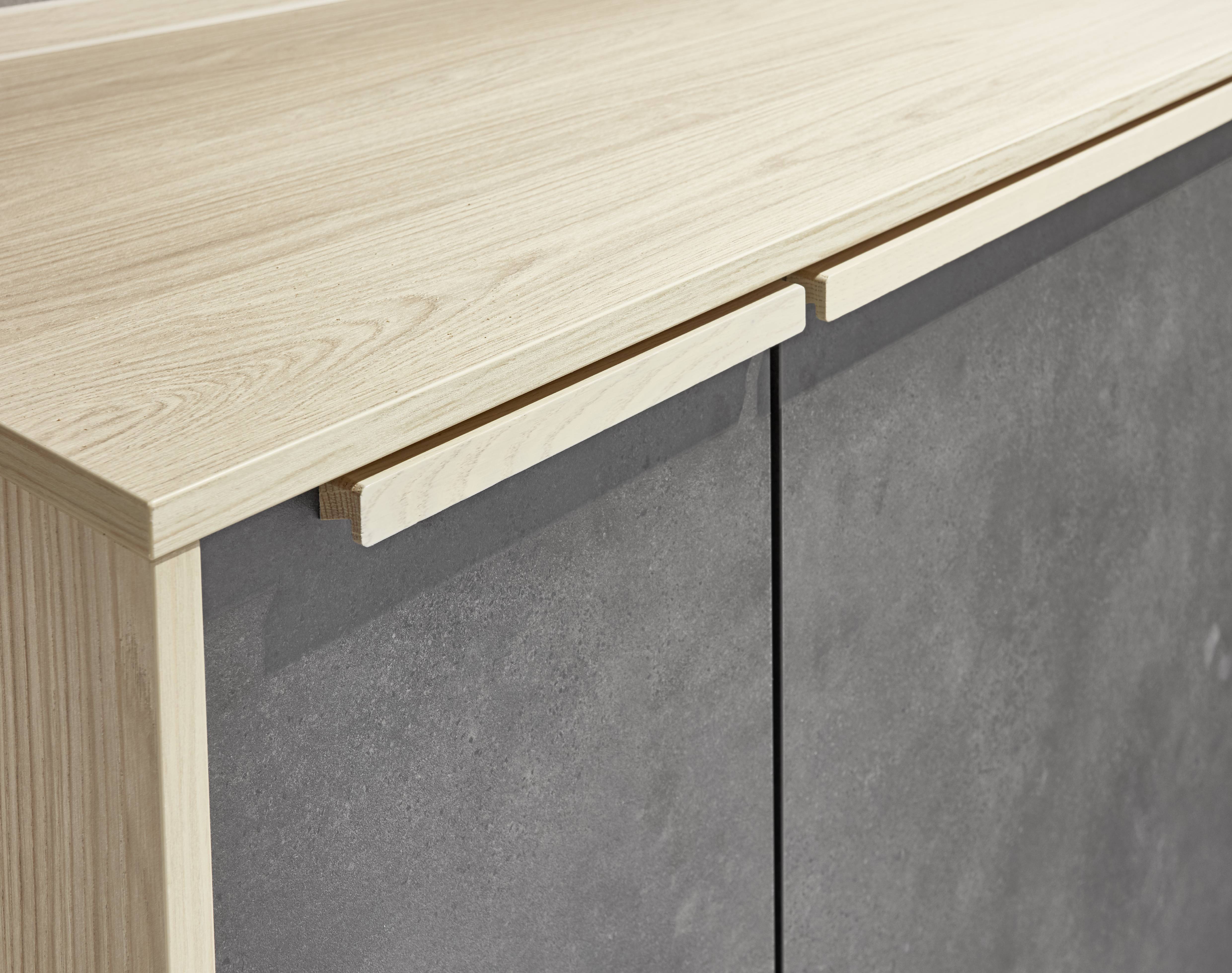Close-up of European-style cabinetry featuring handleless detailing, a warm wood-look countertop, and a stone-look finish for a sleek, minimalist aesthetic.