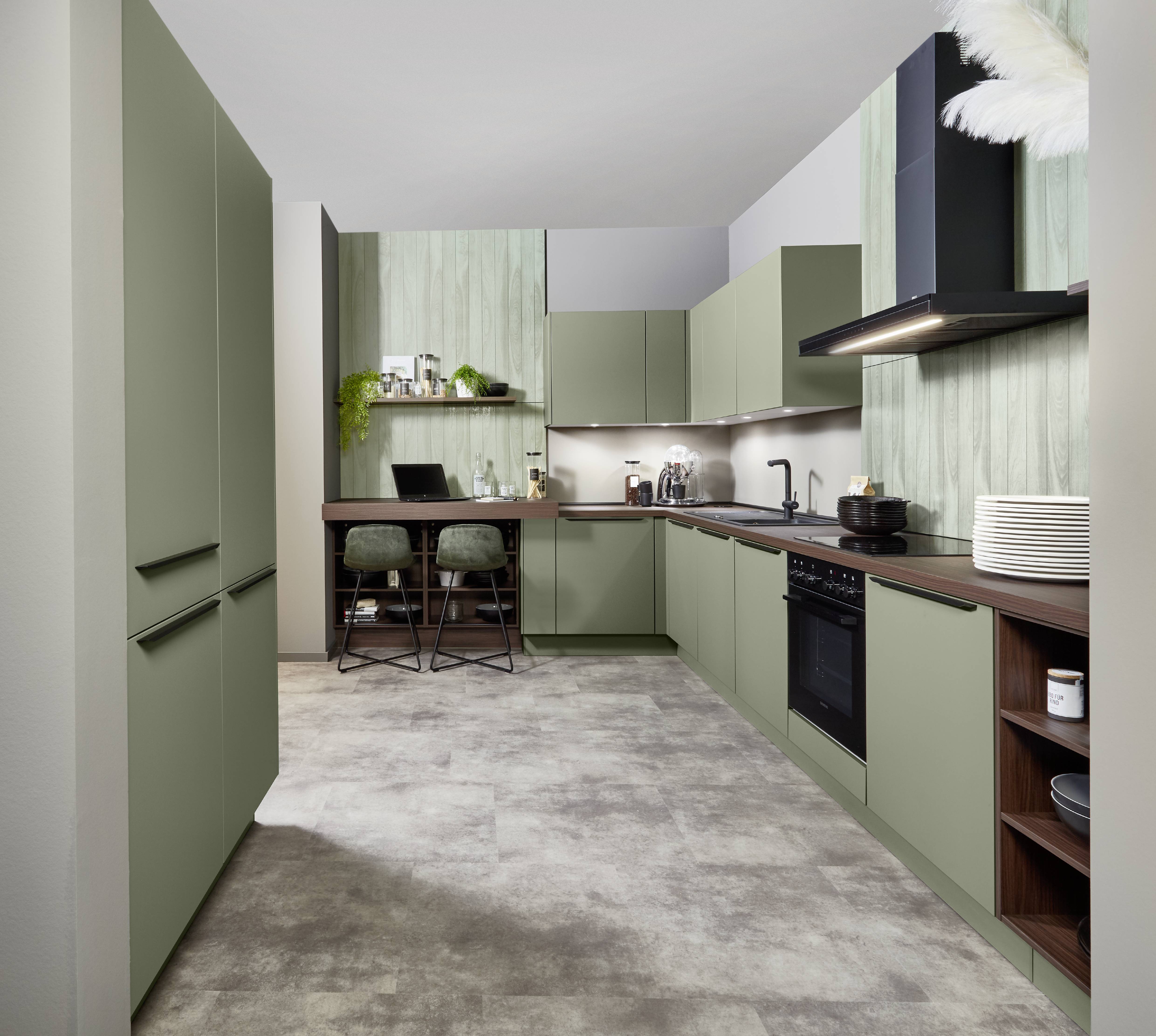 Small modern kitchen with green cabinets, a wood worktop, a built-in desk nook, and efficient storage in a narrow layout