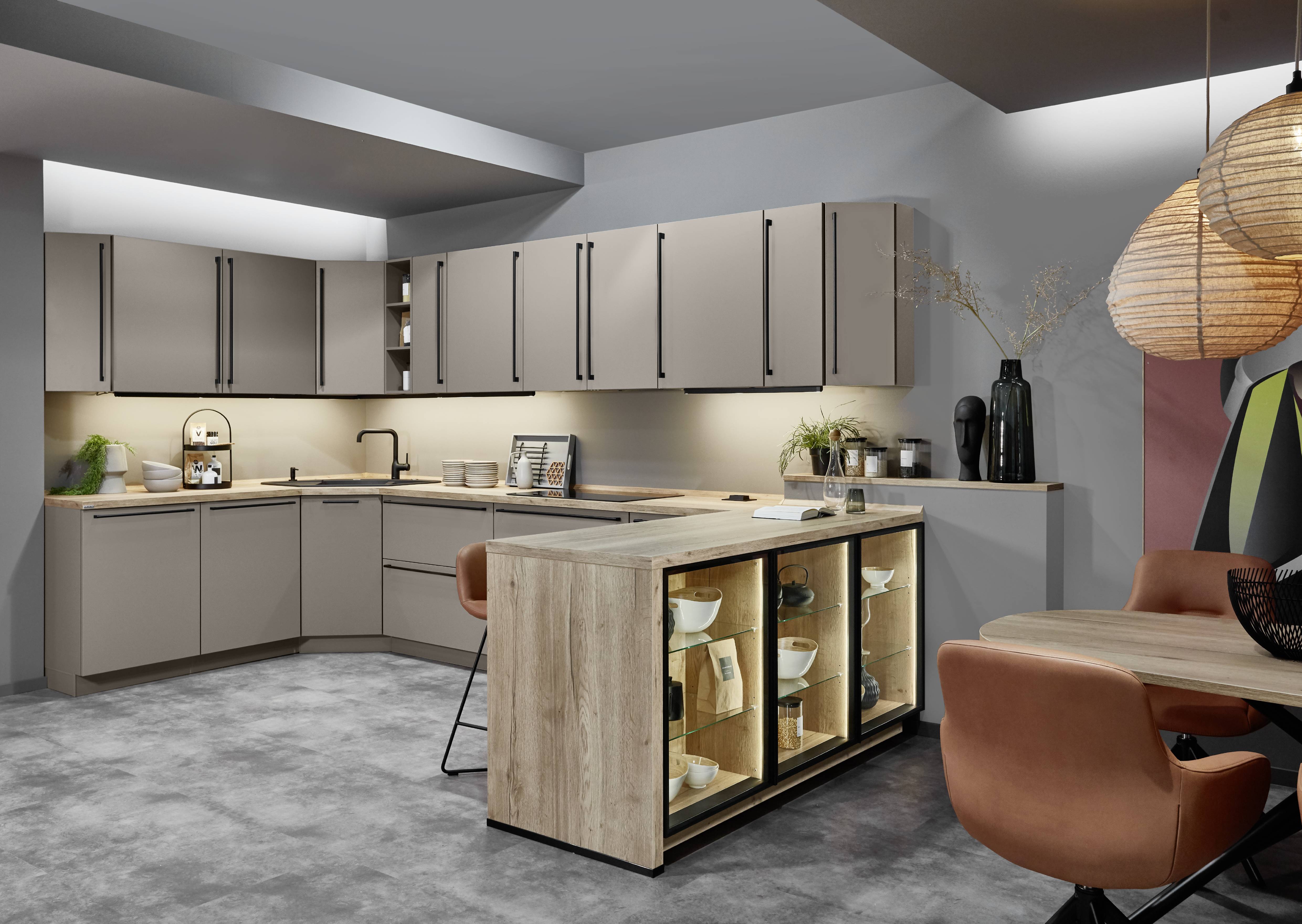 Coordinating wall color with cabinets Warm neutral kitchen cabinets paired with soft wall color and wood accents for a balanced, inviting kitchen palette