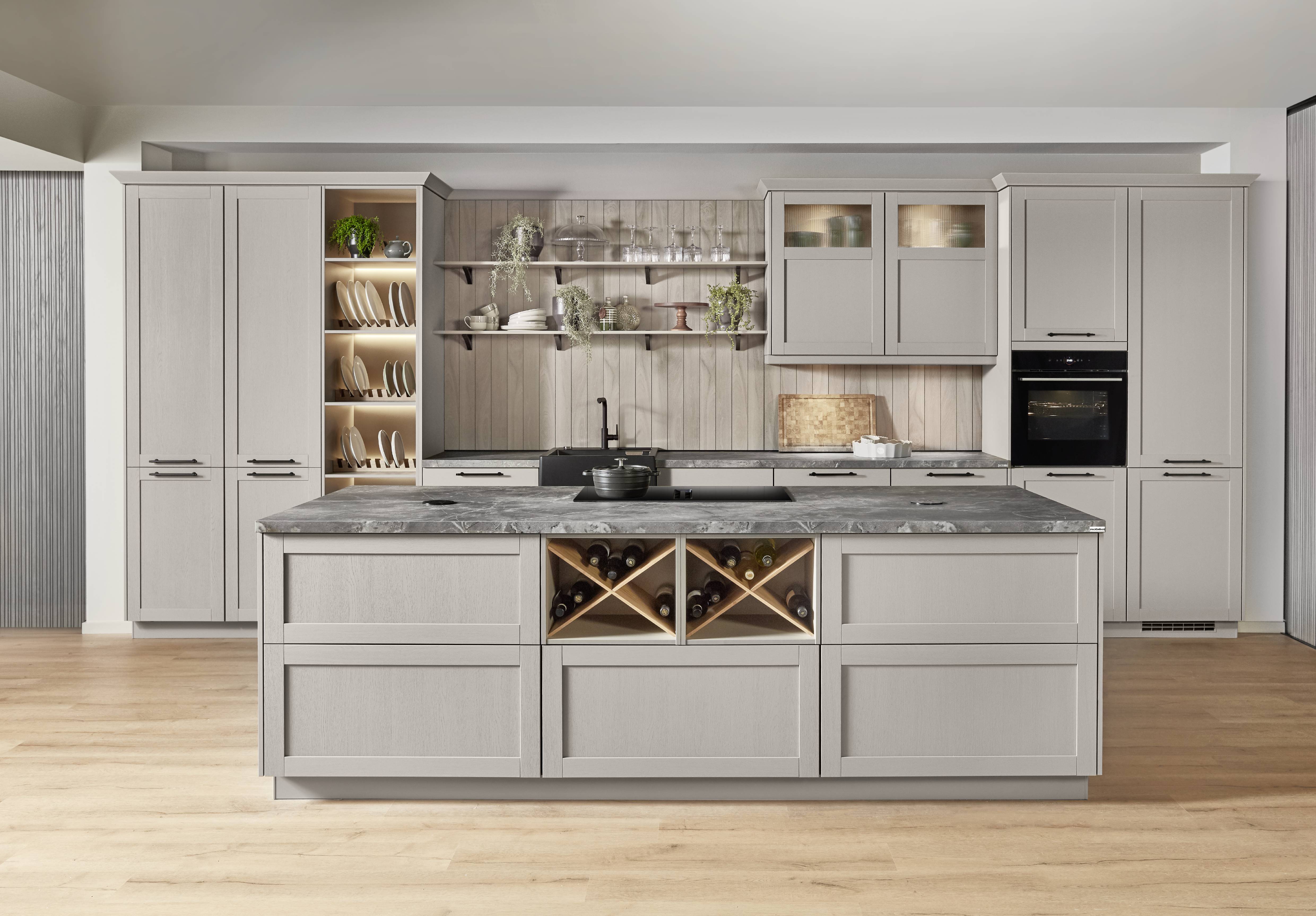 Kitchen island with wine storage and classic cabinetry Gray kitchen with a large island featuring integrated wine storage, stone-look countertop, and open shelving accents