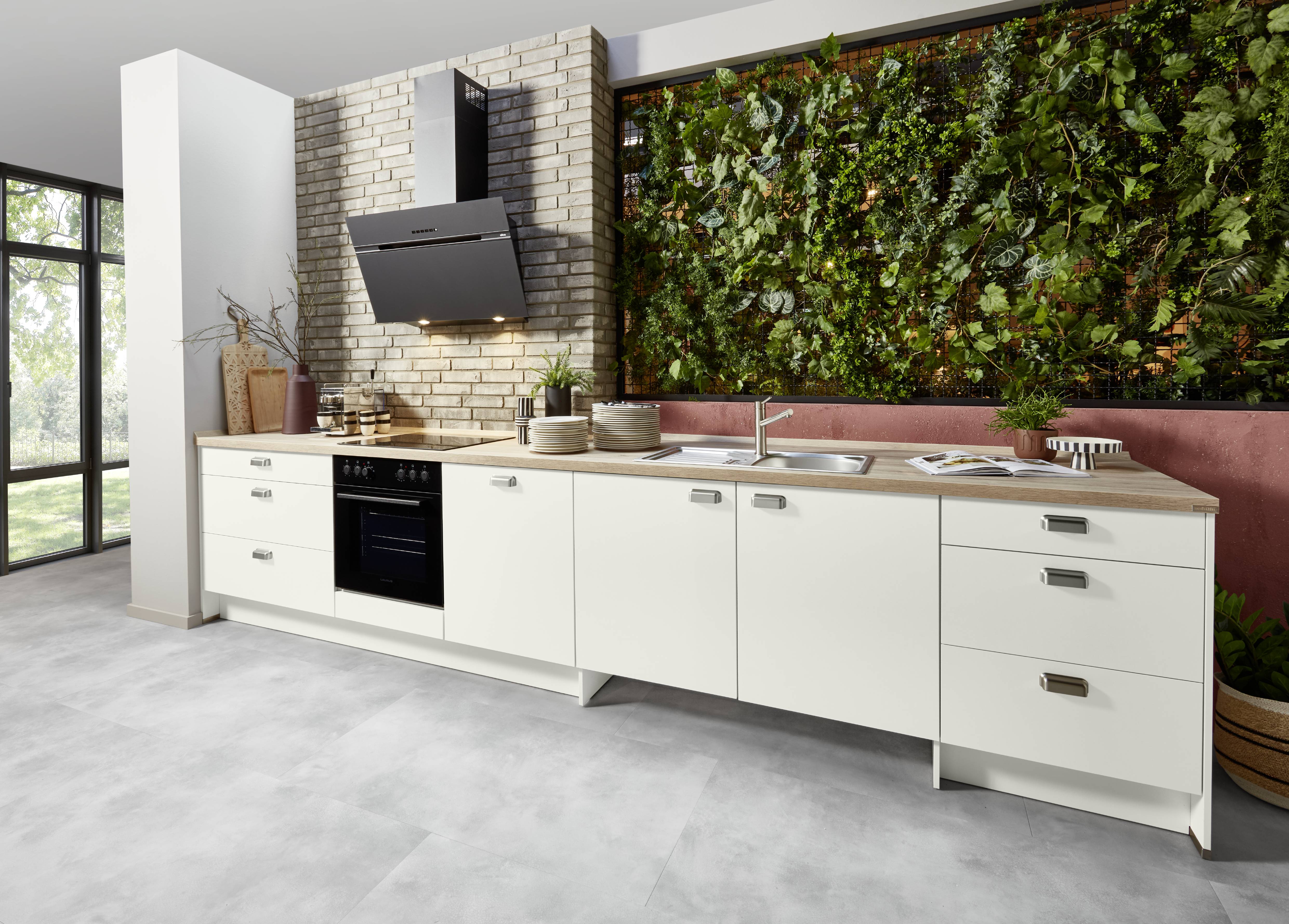 A modern kitchen designed with natural warmth and a fresh, greenery-inspired backdrop