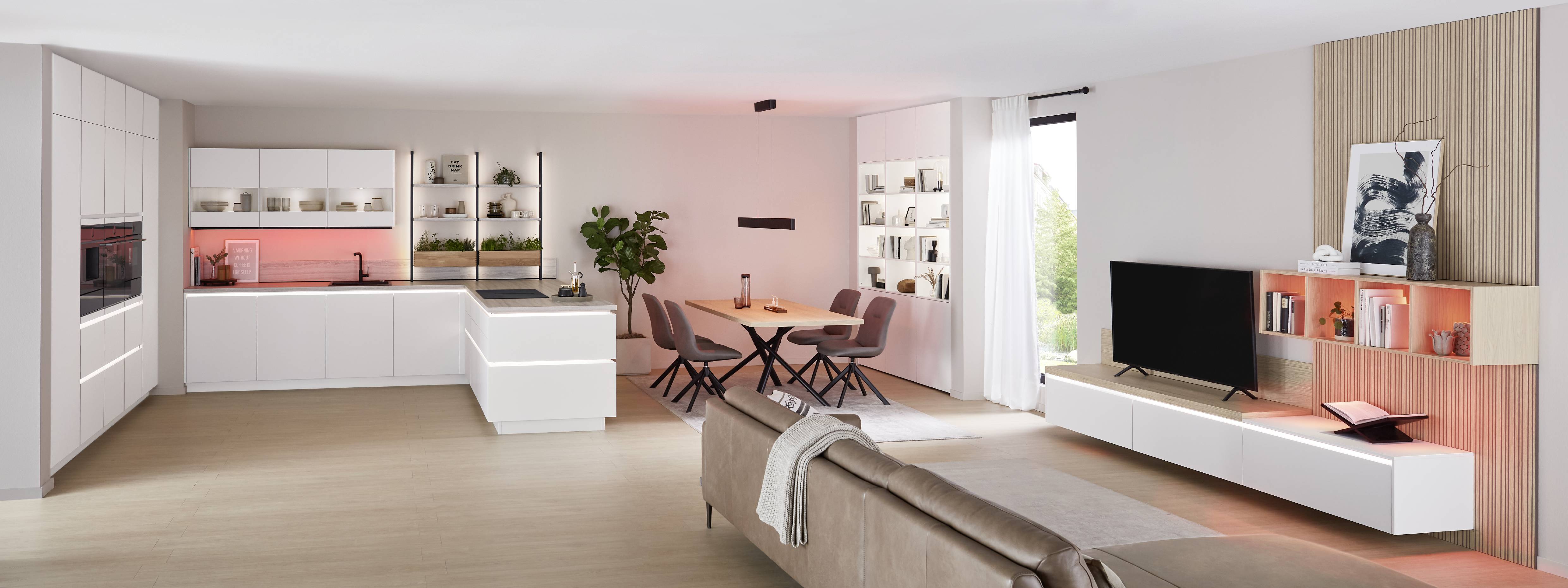 Open plan home with a white kitchen and integrated living storage, featuring accent lighting that improves visibility and creates a calm atmosphere