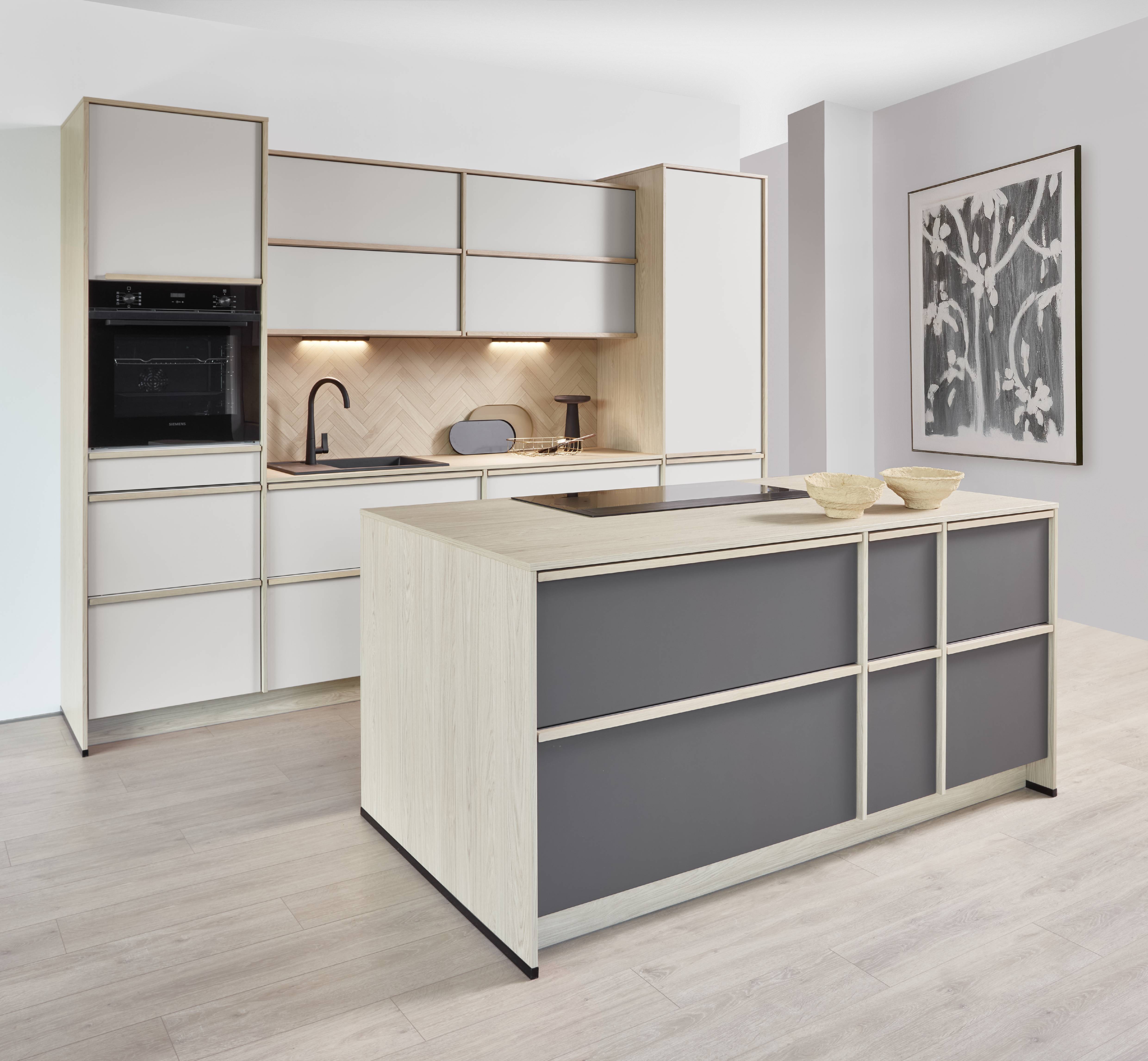 Noblessa USA Modern German Kitchen with Light Wood Cabinetry, Contemporary Island, and Herringbone Backsplash Modern German kitchen with light wood and matte beige cabinetry, a spacious island with dark accent panels, integrated appliances, herringbone backsplash, and minimalist design for a clean, contemporary look.