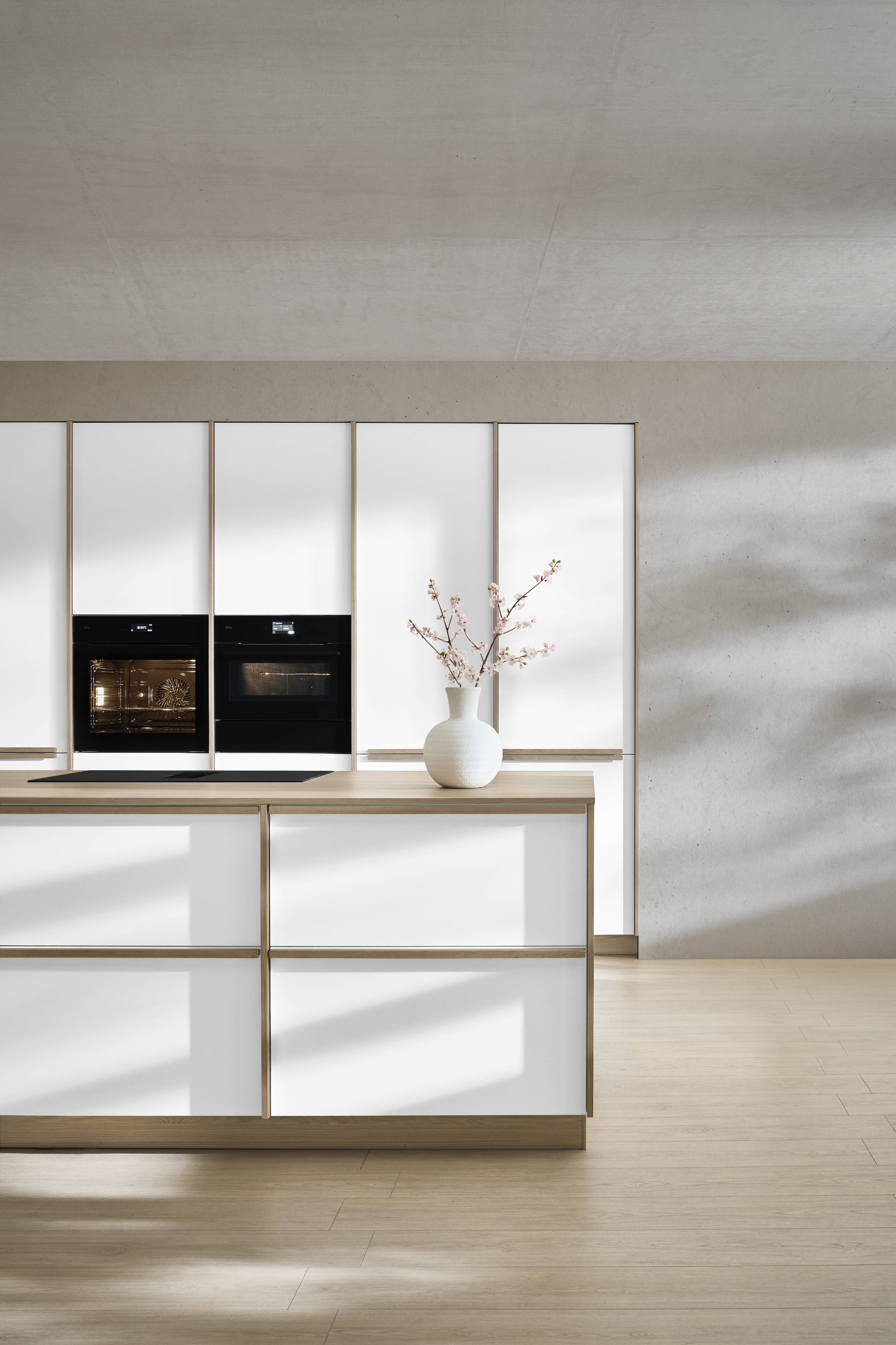 noblessa USA - Modern German Kitchen with Sleek White Cabinetry Modern German kitchen featuring sleek white cabinetry, integrated black appliances, warm wood accents, and minimalist styling.
