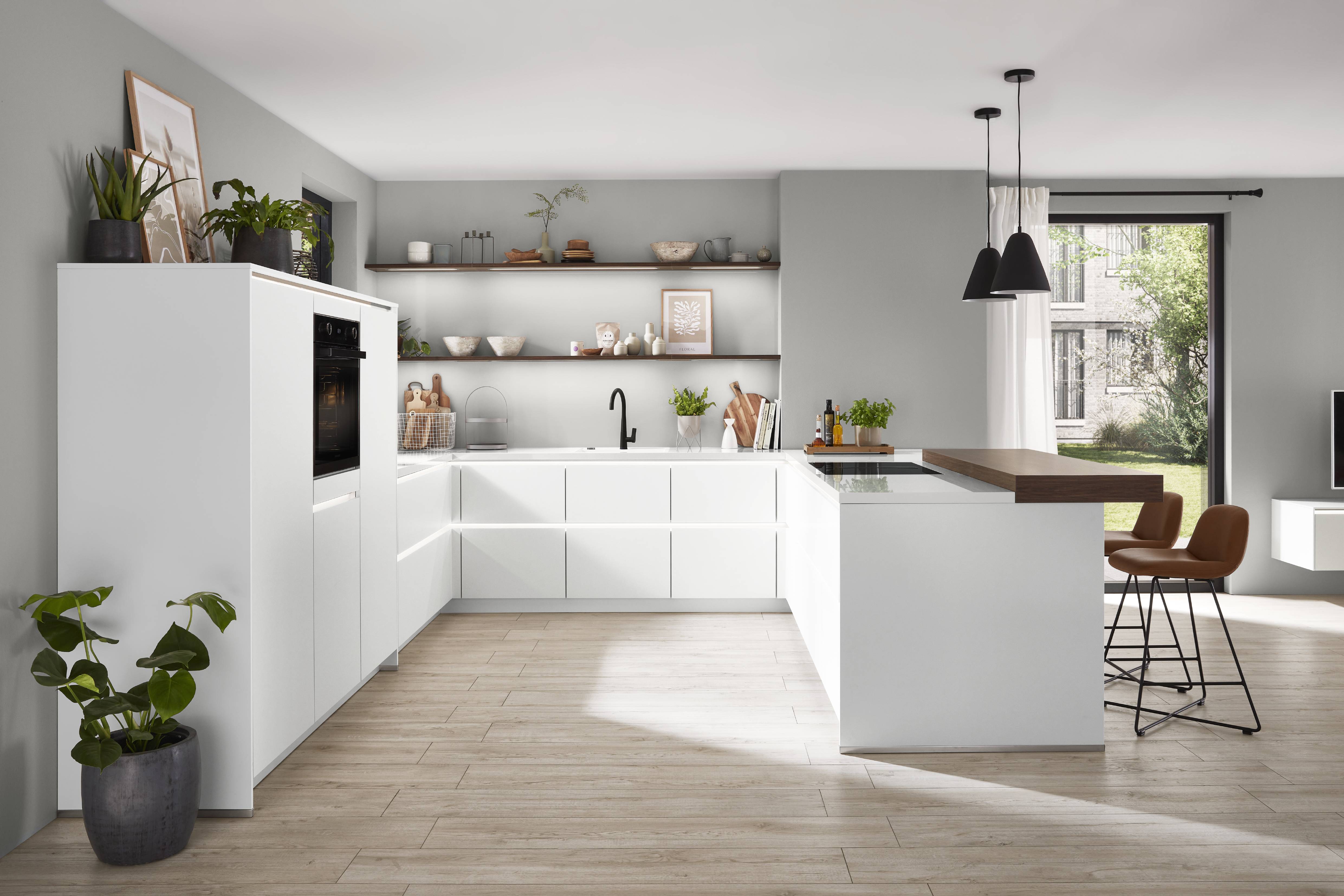 noblesa USA - Bright Modern German Kitchen with White Cabinetry and Wood Accents Bright modern German kitchen with white cabinetry, a wood-accented island, open shelving, integrated appliances, and large windows providing natural light.