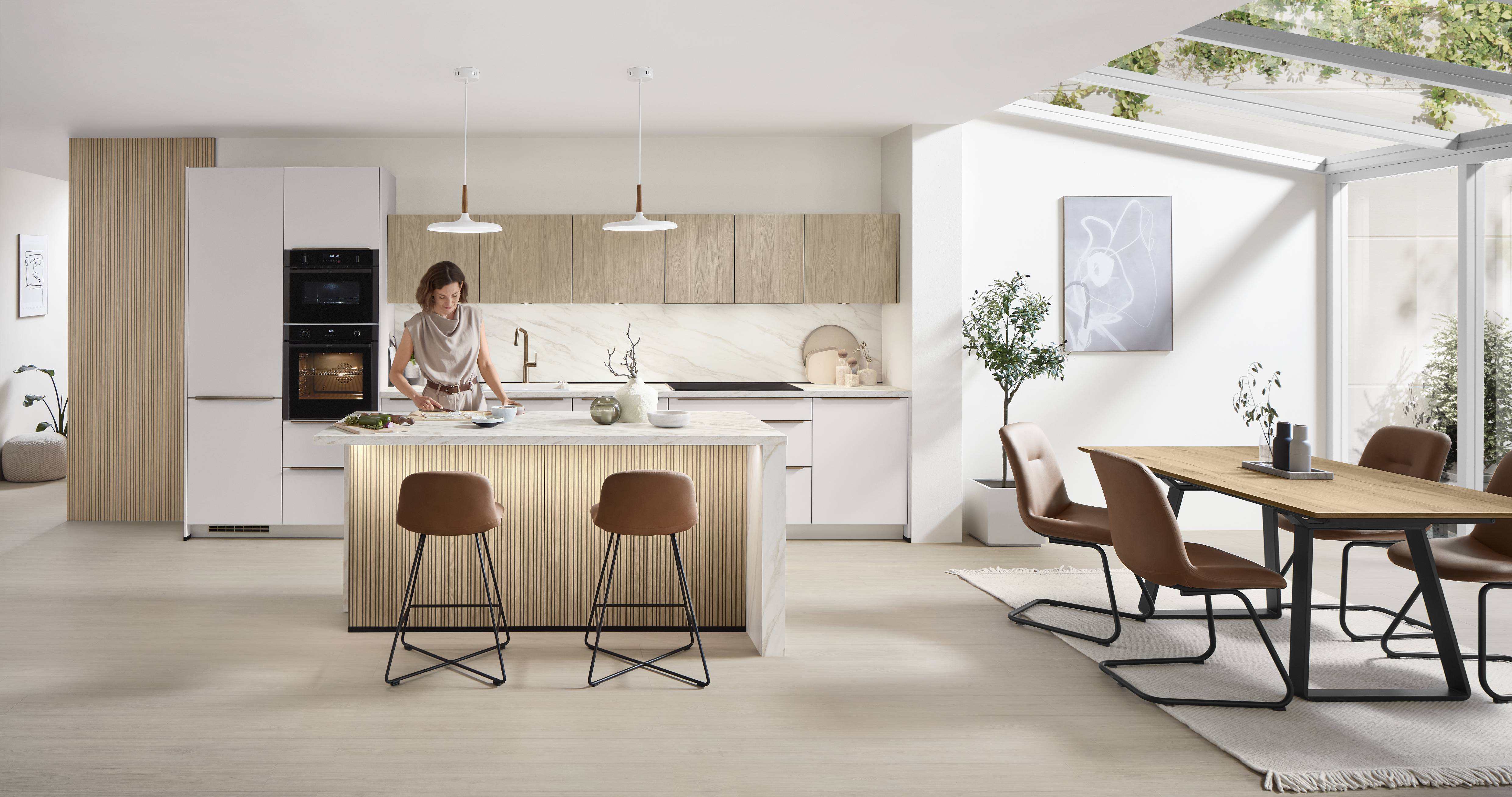 Bright modern kitchen with wood accents, island seating, and open dining area