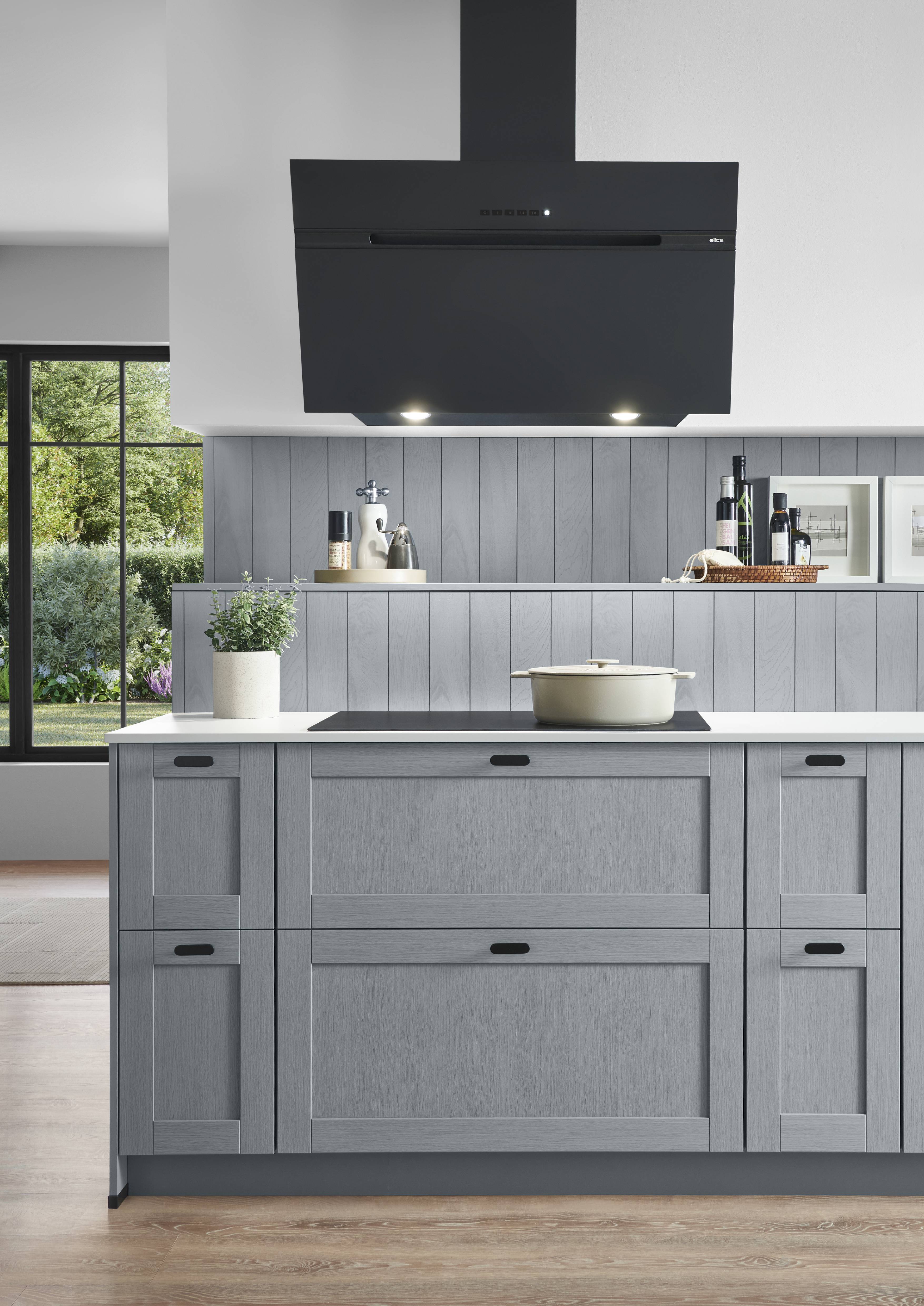 Noblessa USA - Modern Gray German Kitchen with Statement Range Hood Close-up view of a modern German kitchen featuring gray cabinetry, a large black range hood, open shelving, and a light countertop.