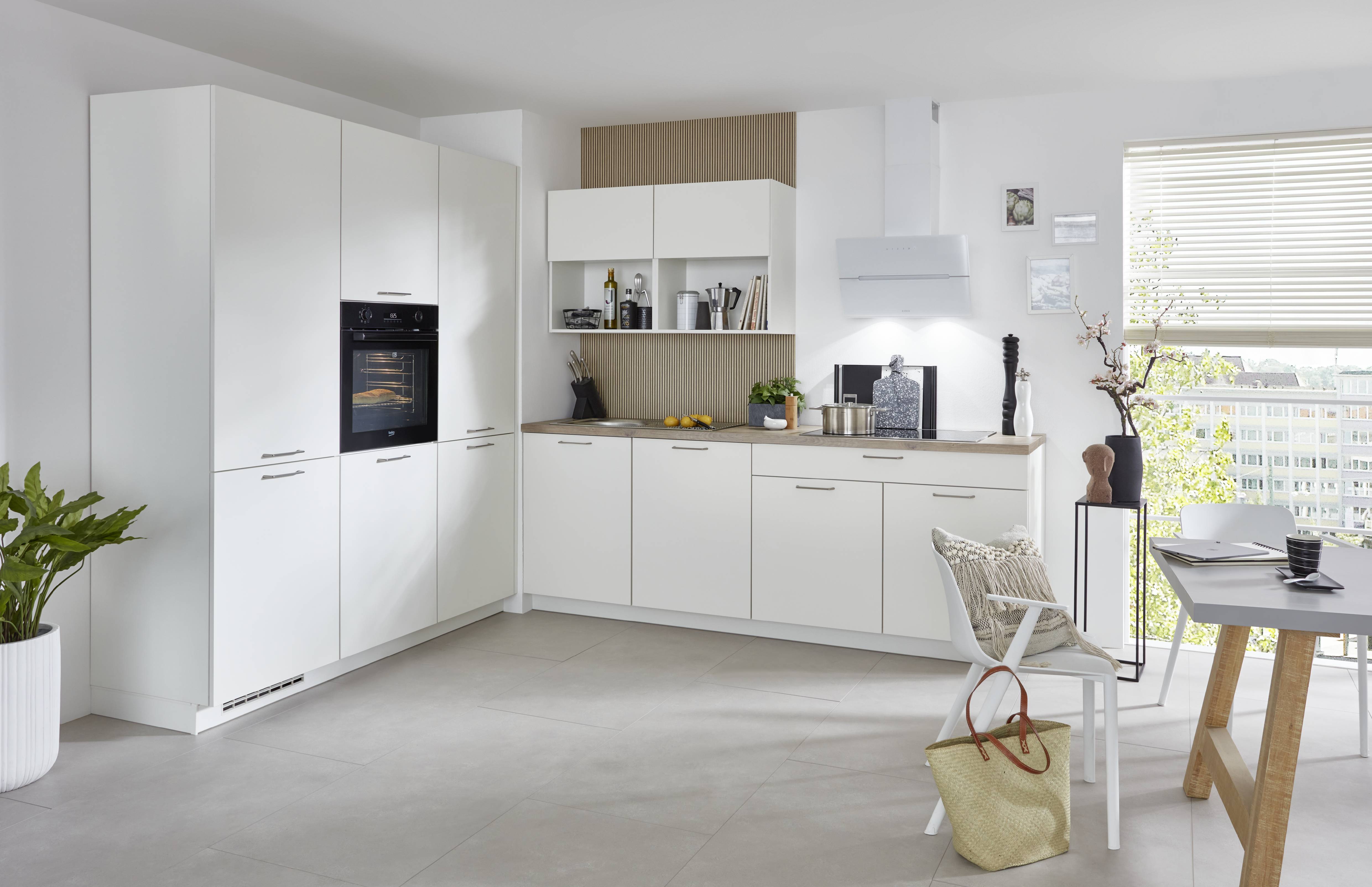 All-white modern kitchen with island All-white modern kitchen with integrated cabinetry, a large island with seating, and a bright open-plan layout