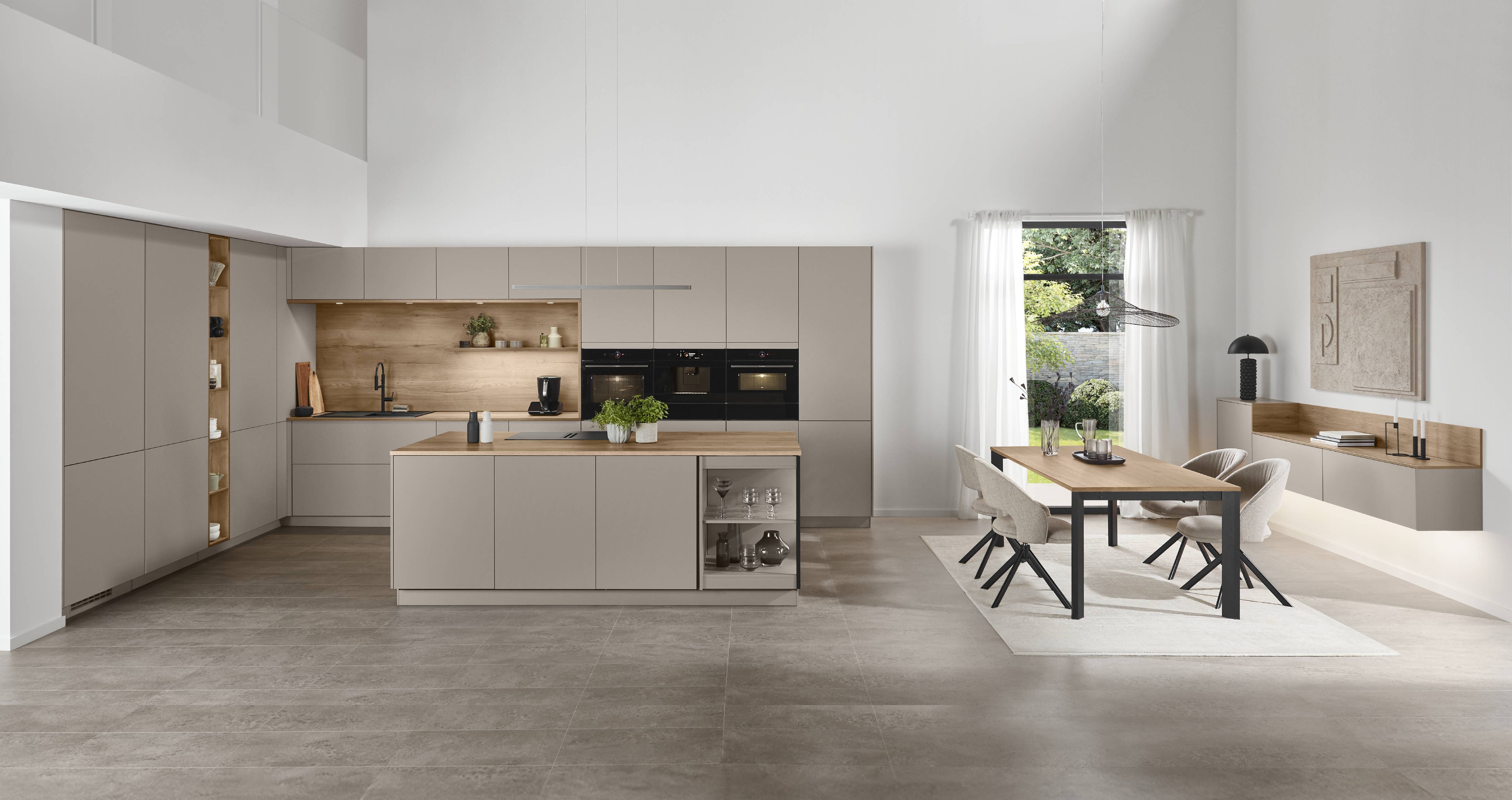 Minimal modern kitchen in warm taupe cabinetry with wood backsplash and island, built-in appliances, and an open dining area in a bright, high-ceiling space. Warm Taupe Modern Kitchen with Wood Accents and Island