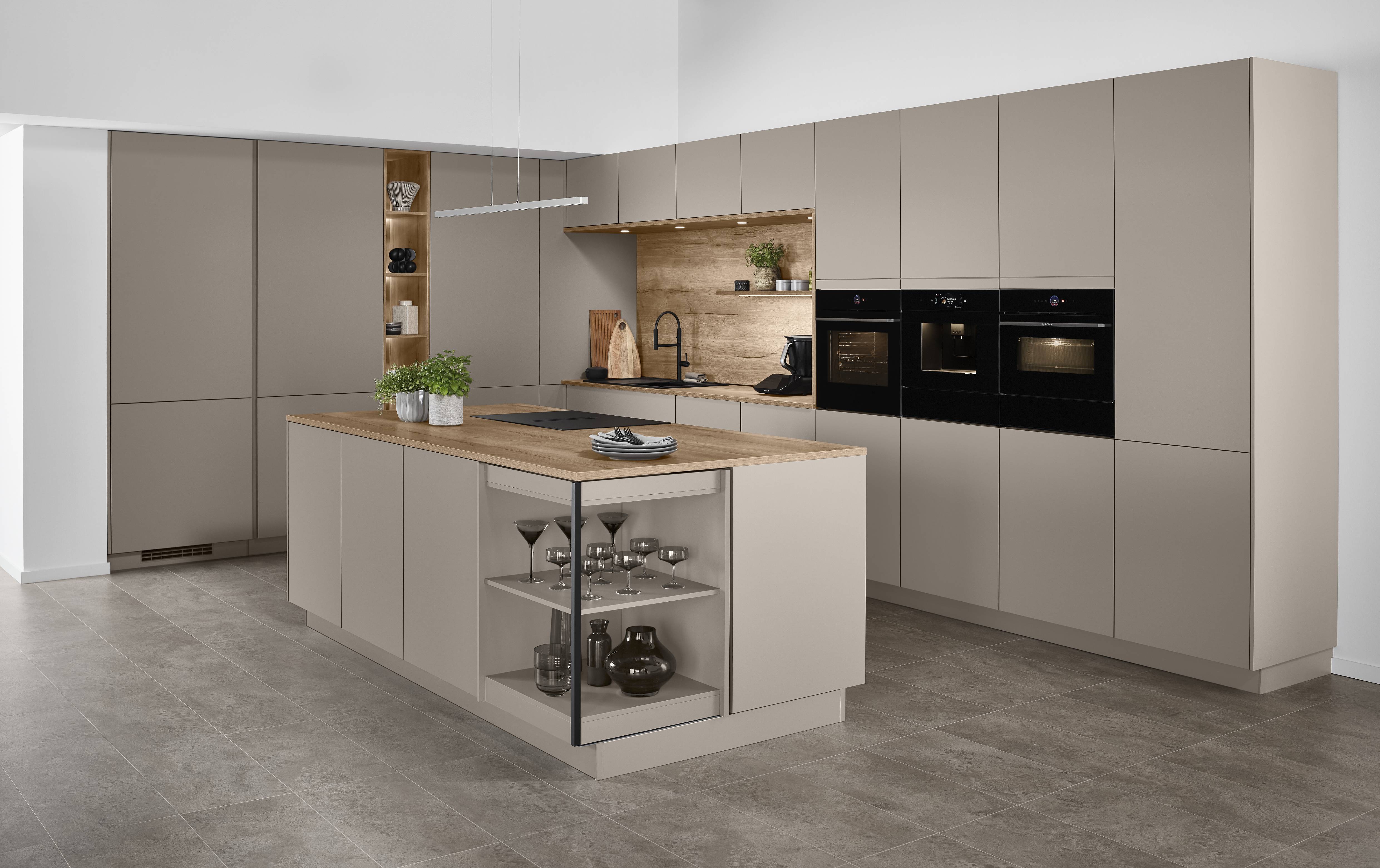 A sophisticated Noblessa USA German kitchen featuring matte taupe cabinetry, warm wood accents, and a multifunctional island designed for seamless everyday living.