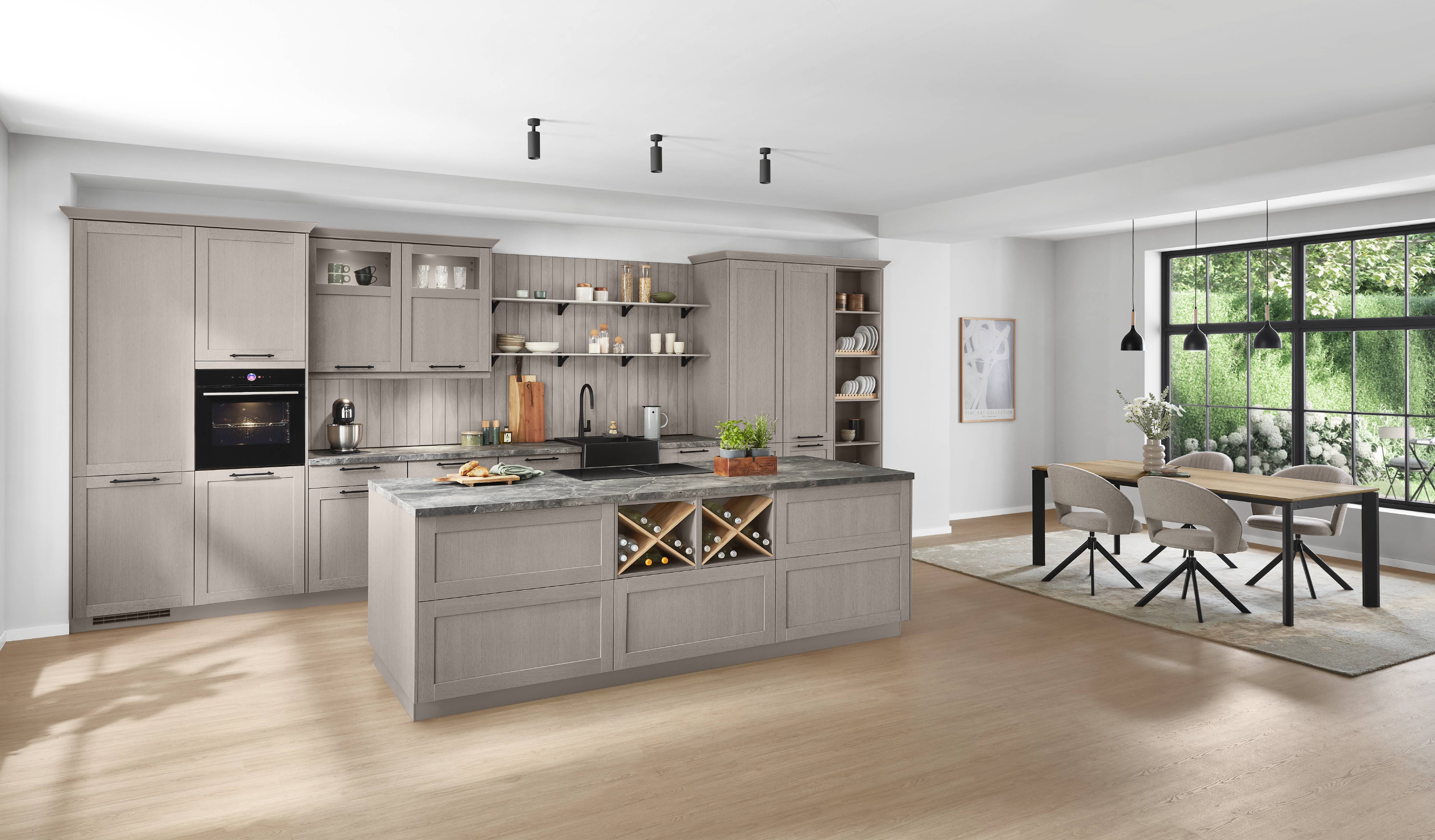 Elegant German kitchen with taupe-gray cabinetry, open shelving, integrated appliances, a large island with built-in wine storage, and a bright dining area overlooking a garden.