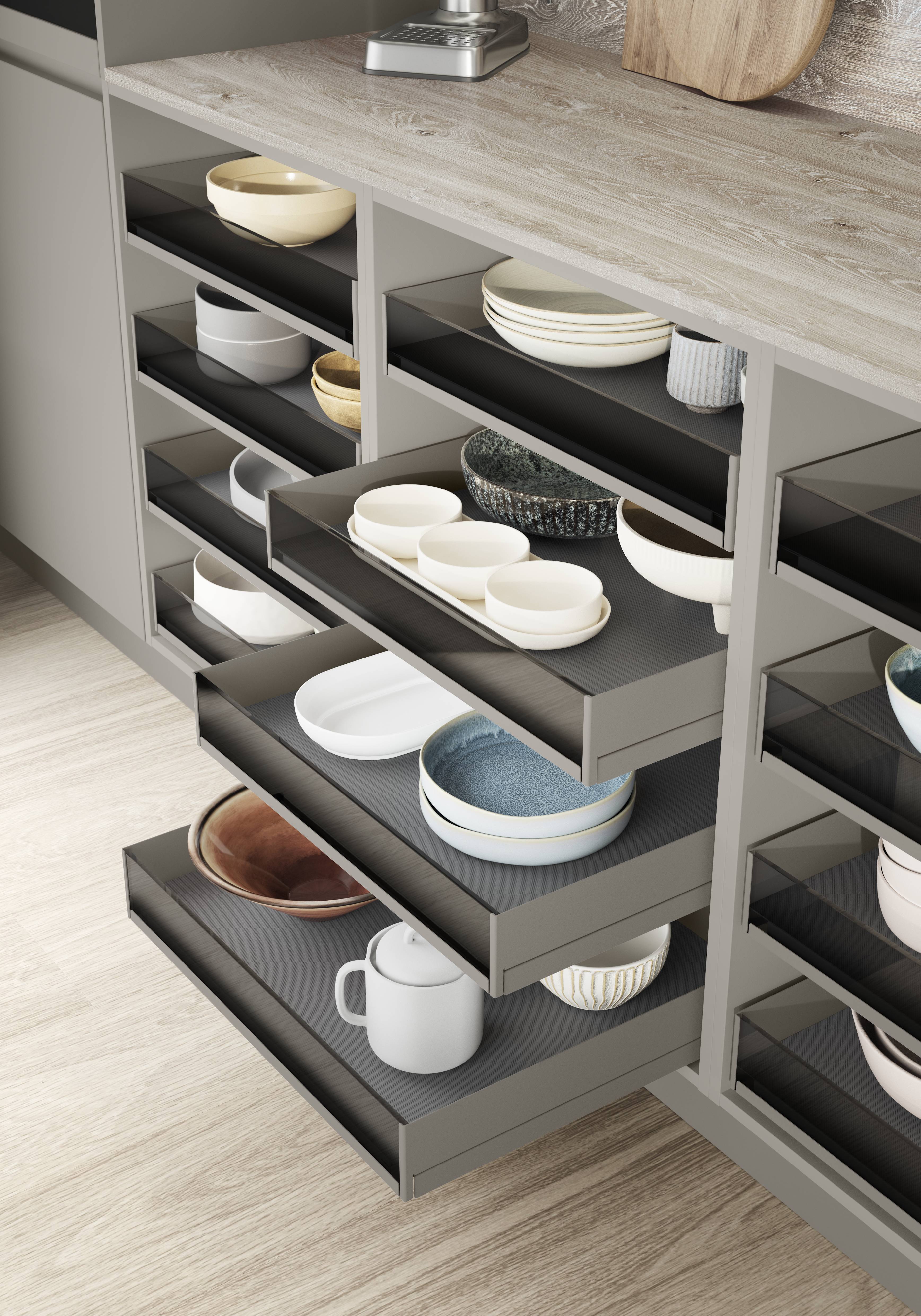 European kitchen cabinet storage system — noblessa pull-out tiered shelving with organized crockery inside a custom kitchen drawer