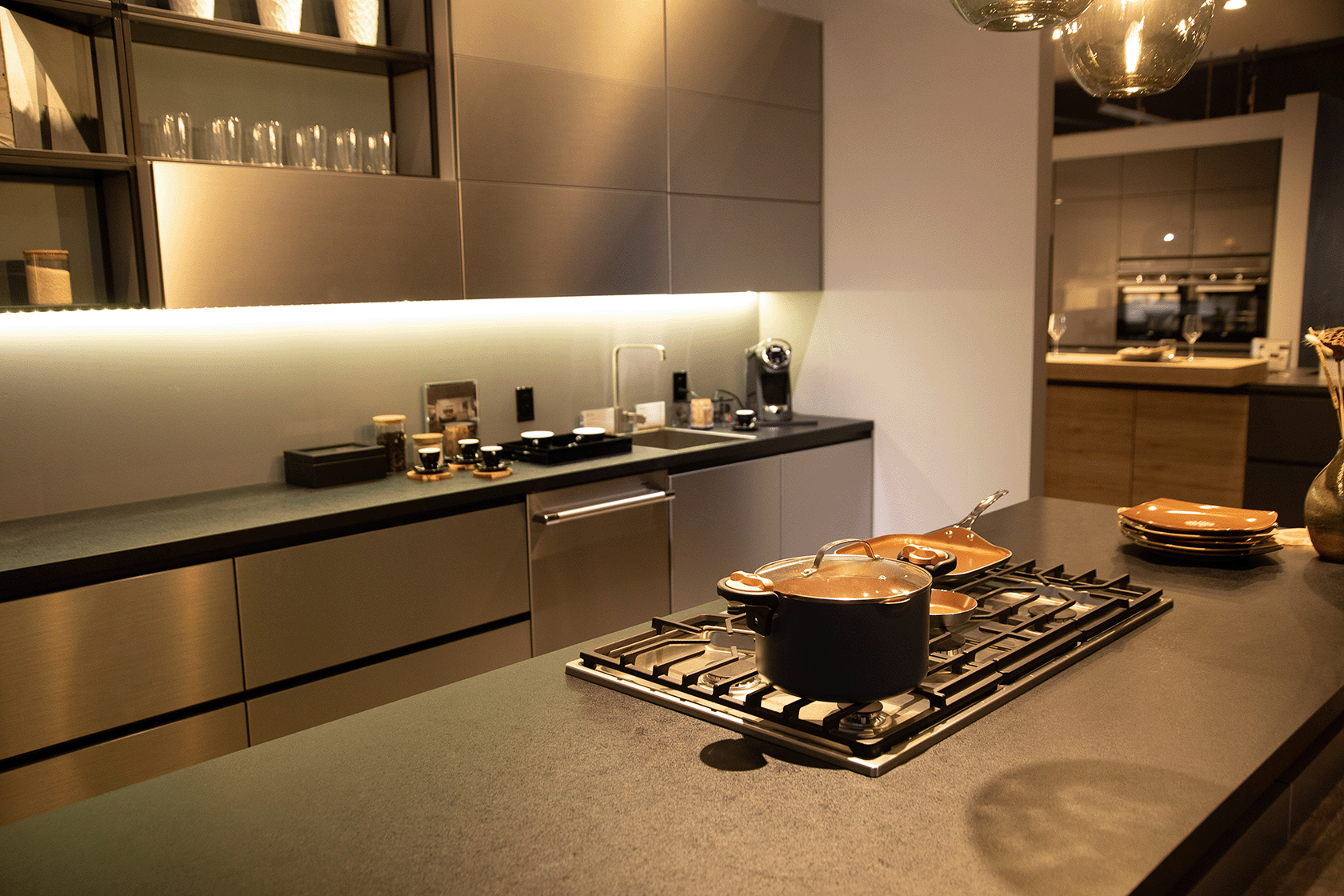 A high-end kitchen includes built-in appliances. This counter in the Pasadena showroom showcases an integrated downdraft cooktop.