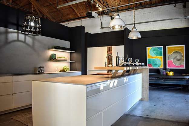 Pasadena kitchen showroom display. Island counter with glossy white finish and light wood counter top.