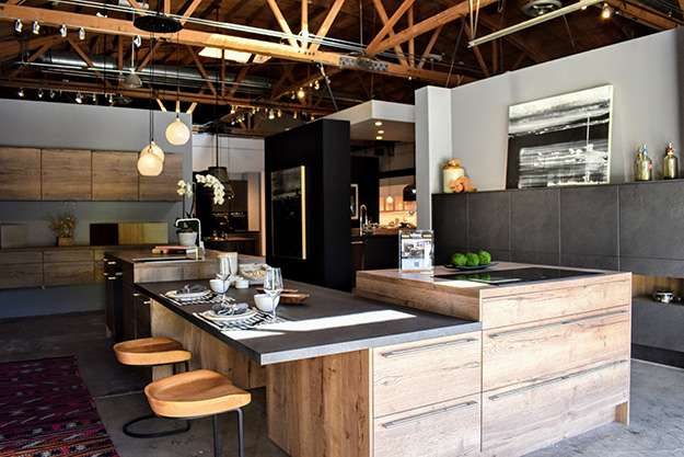 Pasadena kitchen showroom display. L-shaped kitchen display with integrated breakfast bar. Cabinets feature a natural wood finish.